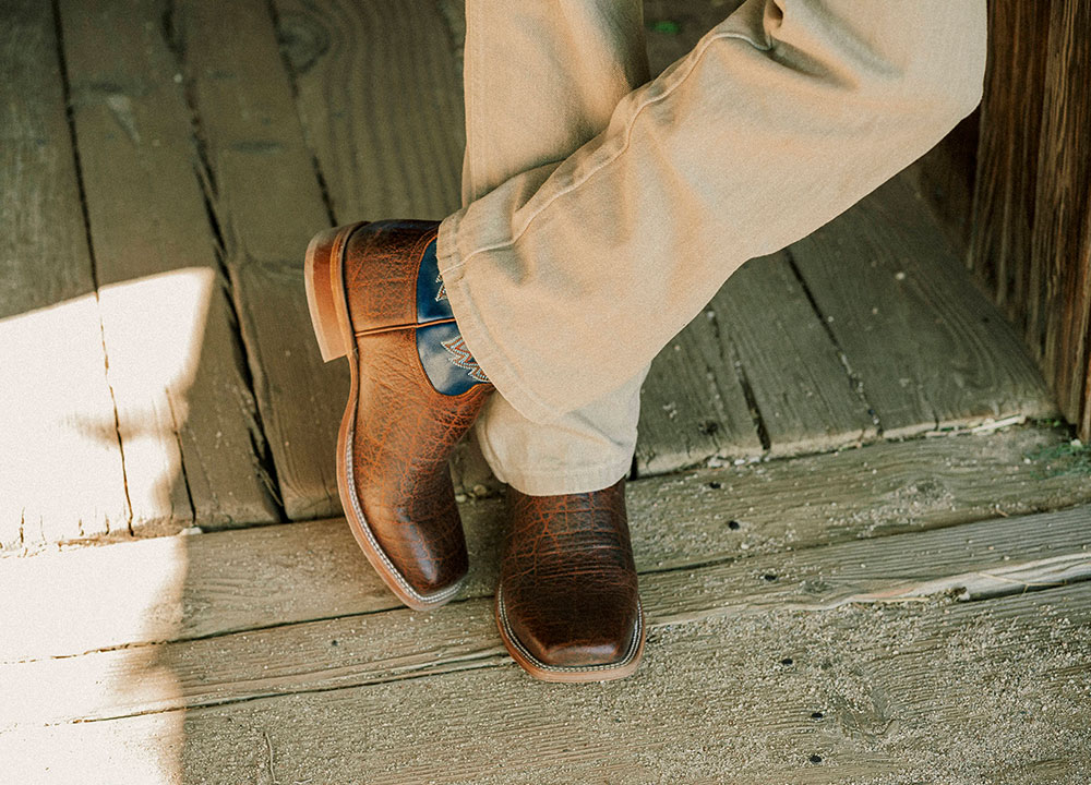 A Man Wearing the Jinglebob 11" Pull-On Western Boots in Brown